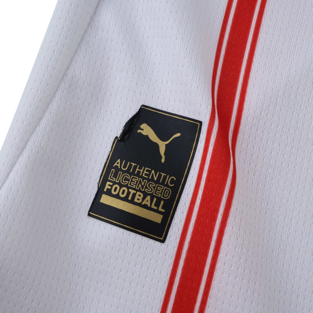 Close-up of Girona Home 2025/26 fan version jersey showing Puma authentic licensed football badge.