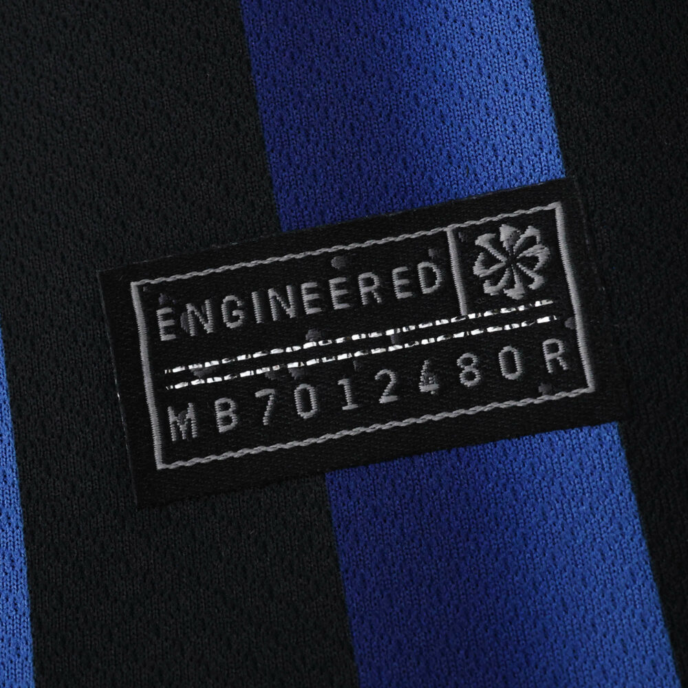 Close-up of the "Engineered" label on the Inter Milan 2025/26 Home Fan Version jersey with blue and black stripes.
