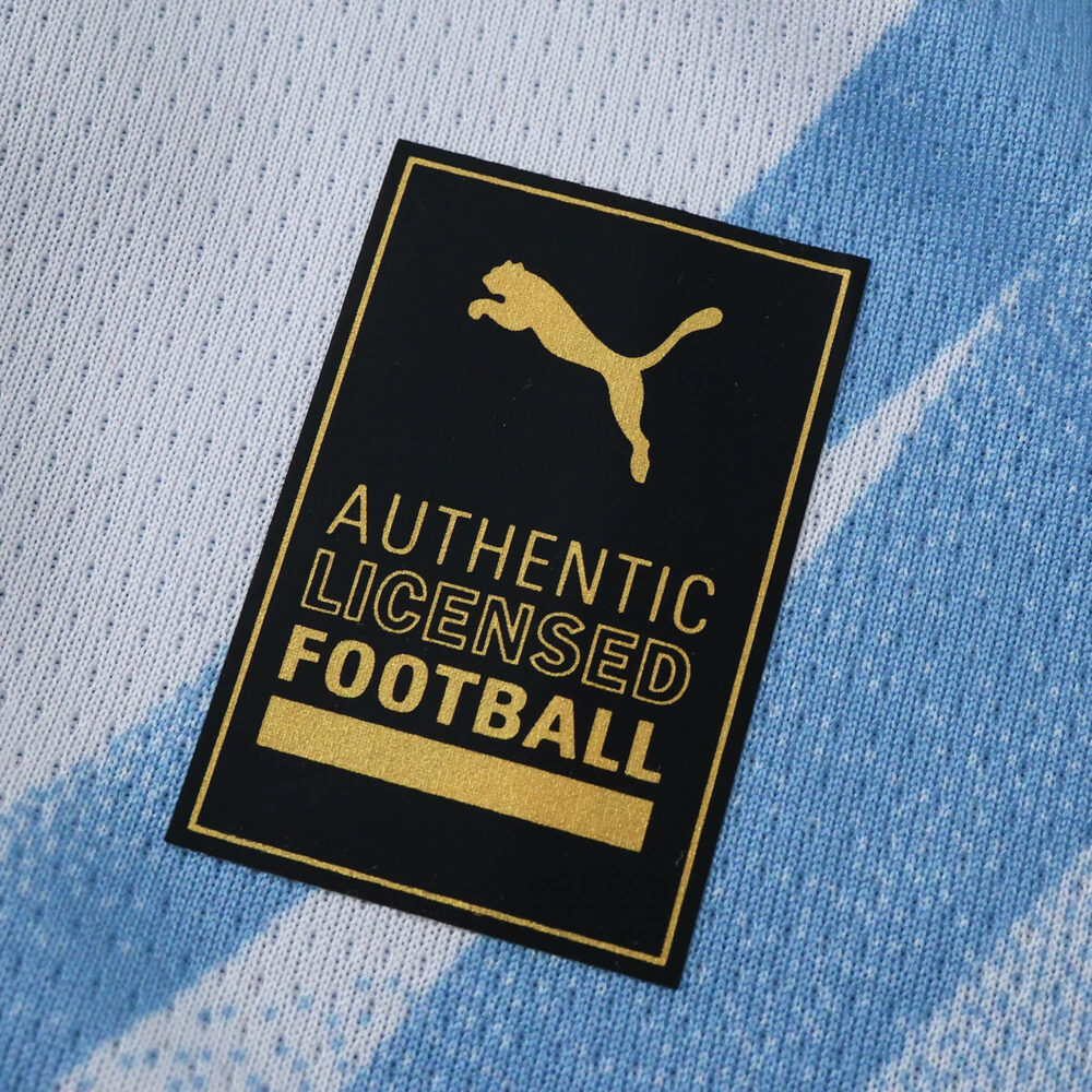 Close-up of the Puma Authentic Licensed Football badge on Manchester City 2025/26 home fan jersey.