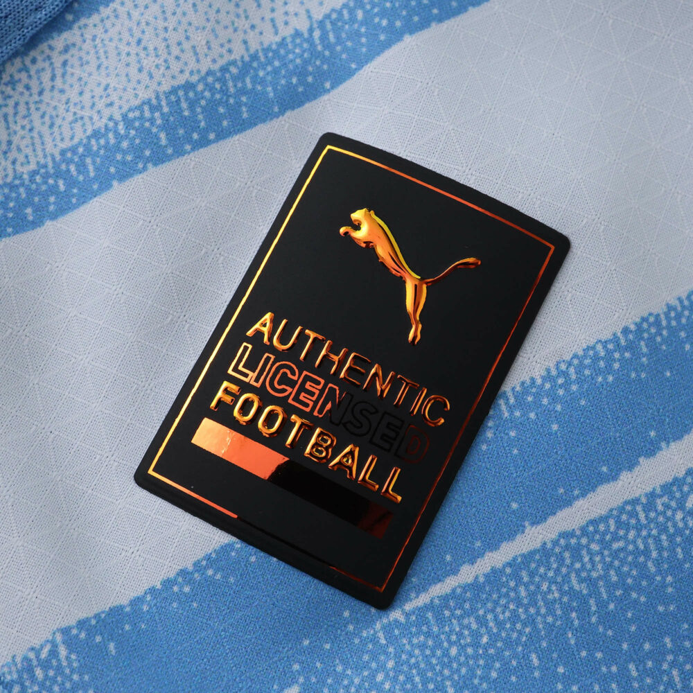 Close-up of Puma Authentic Licensed Football badge on the 2025/26 Manchester City Home Player Version shirt.