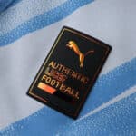 Close-up of Puma Authentic Licensed Football badge on the 2025/26 Manchester City Home Player Version shirt.
