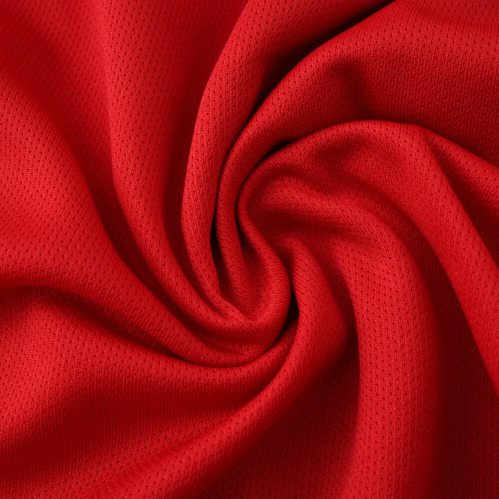 Red Manchester United Home 2025/26 Fan Version jersey fabric with textured spiral fold pattern.