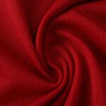 Close-up of red, breathable fabric for Manchester United Home 2025/26 Player Version jersey.