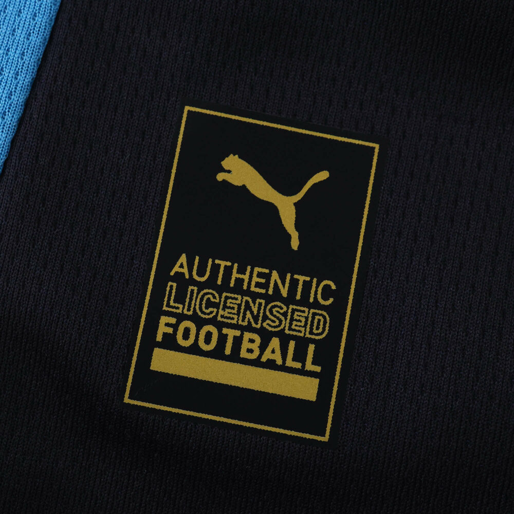 Close-up of the Authentic Licensed Football Puma badge on the Olympique Marseille Away 2025/26 Fan Version shirt.