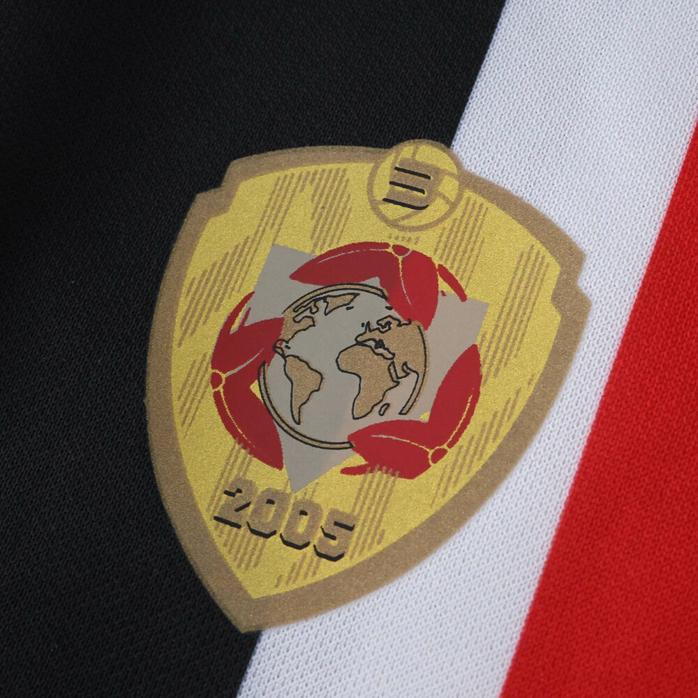 Gold 2005 FIFA Club World Cup badge on São Paulo Away 2025/26 Fan Version jersey, with black, white, and red stripes.