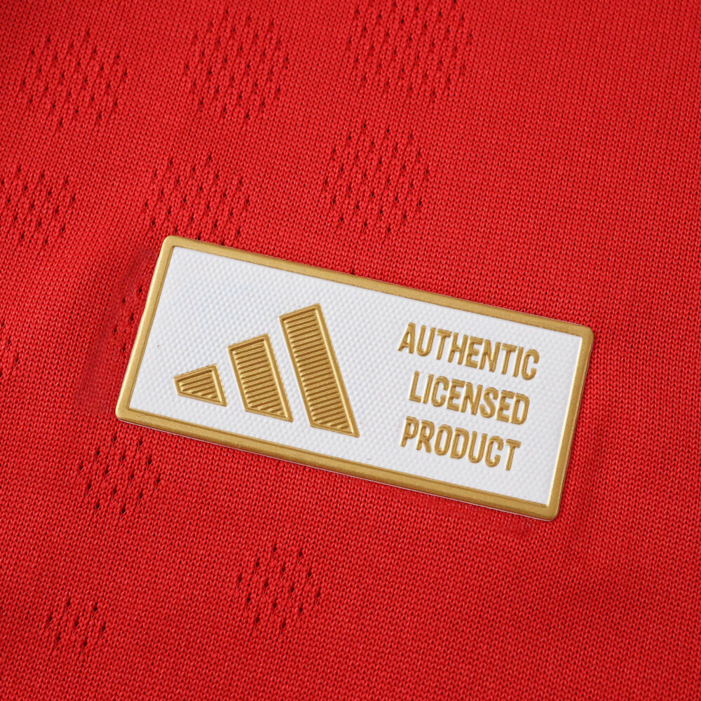Close-up of authenticity badge on SL Benfica Home 2025/26 Player Version jersey, featuring gold Adidas logo.
