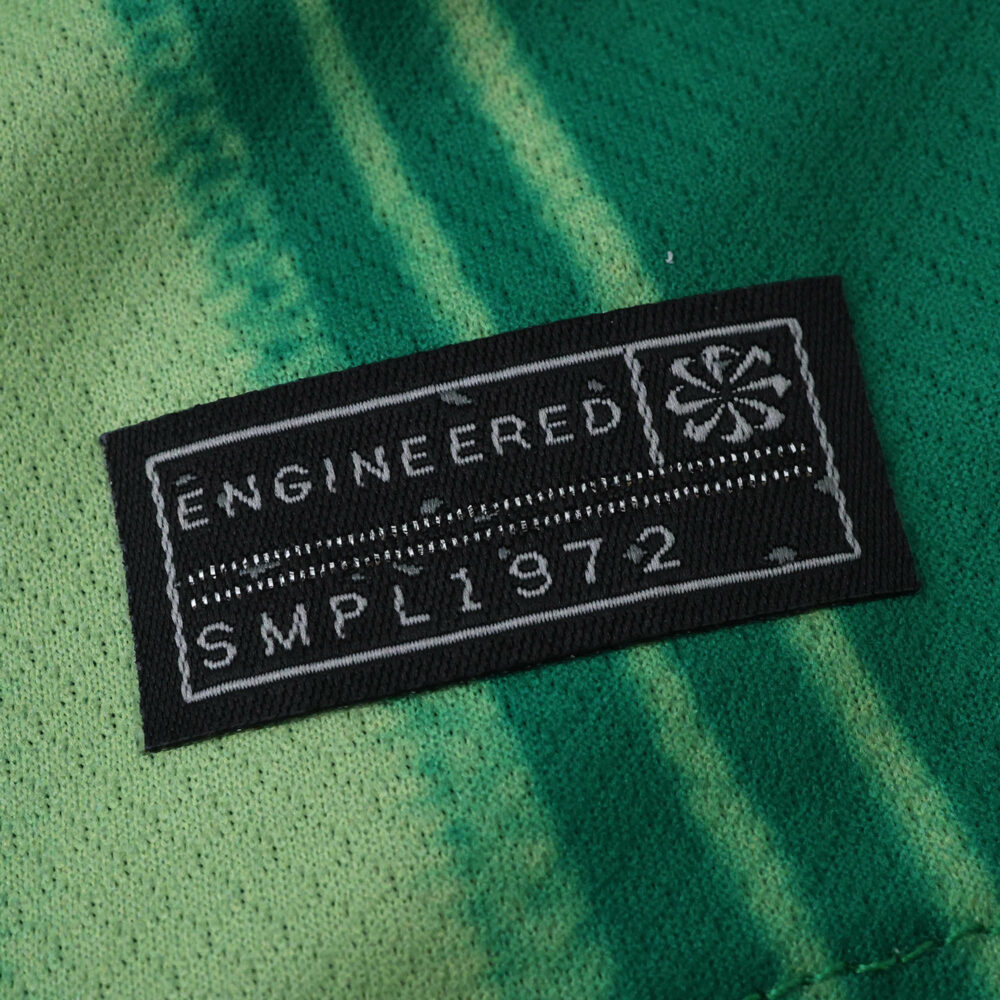 Close-up of "ENGINEERED SMPL1972" tag on the VfL Wolfsburg 2025/26 Home Fan Version jersey.