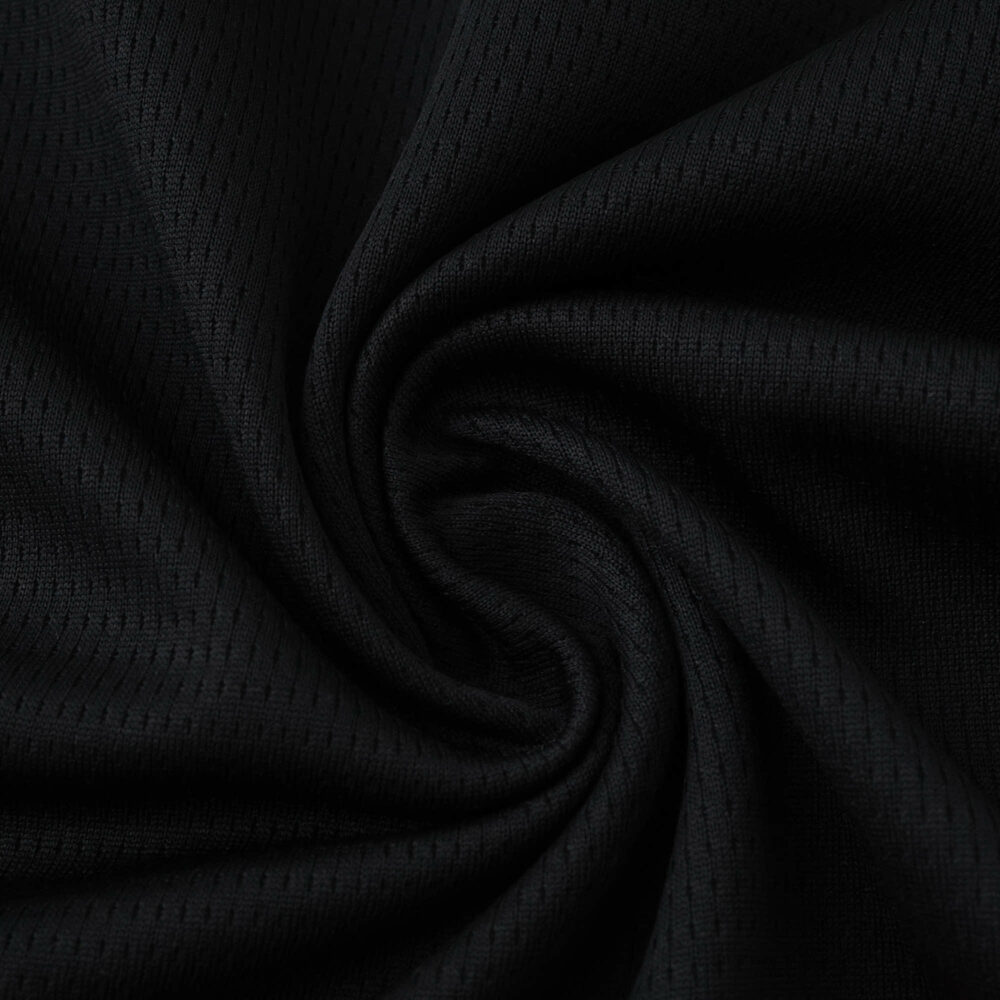 Close-up of black AC Milan 2025/26 Home Fan Version jersey fabric, showing texture and weave pattern.