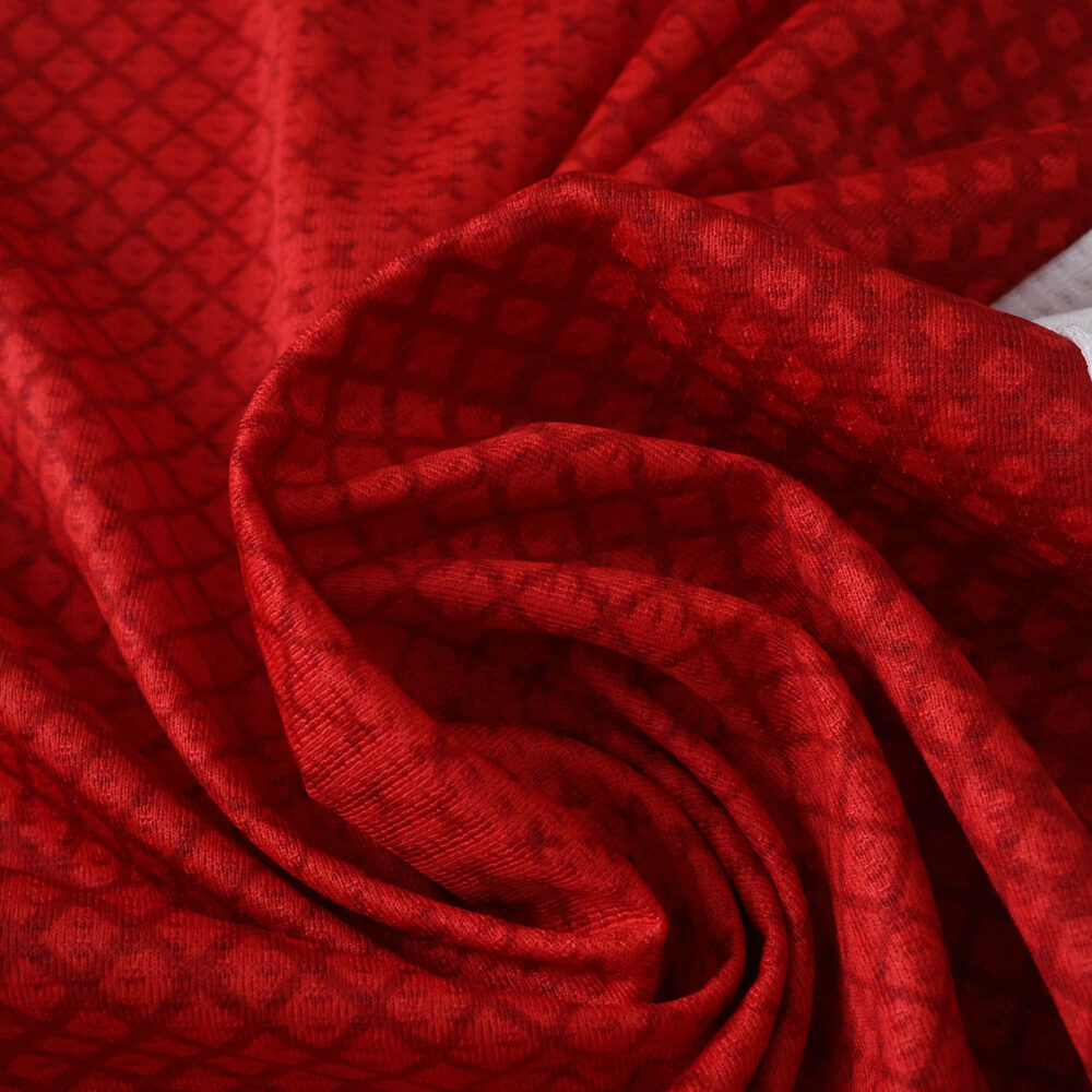 Close-up of Ajax Home 2025/26 Player Version jersey fabric, showing red color and geometric patterns.
