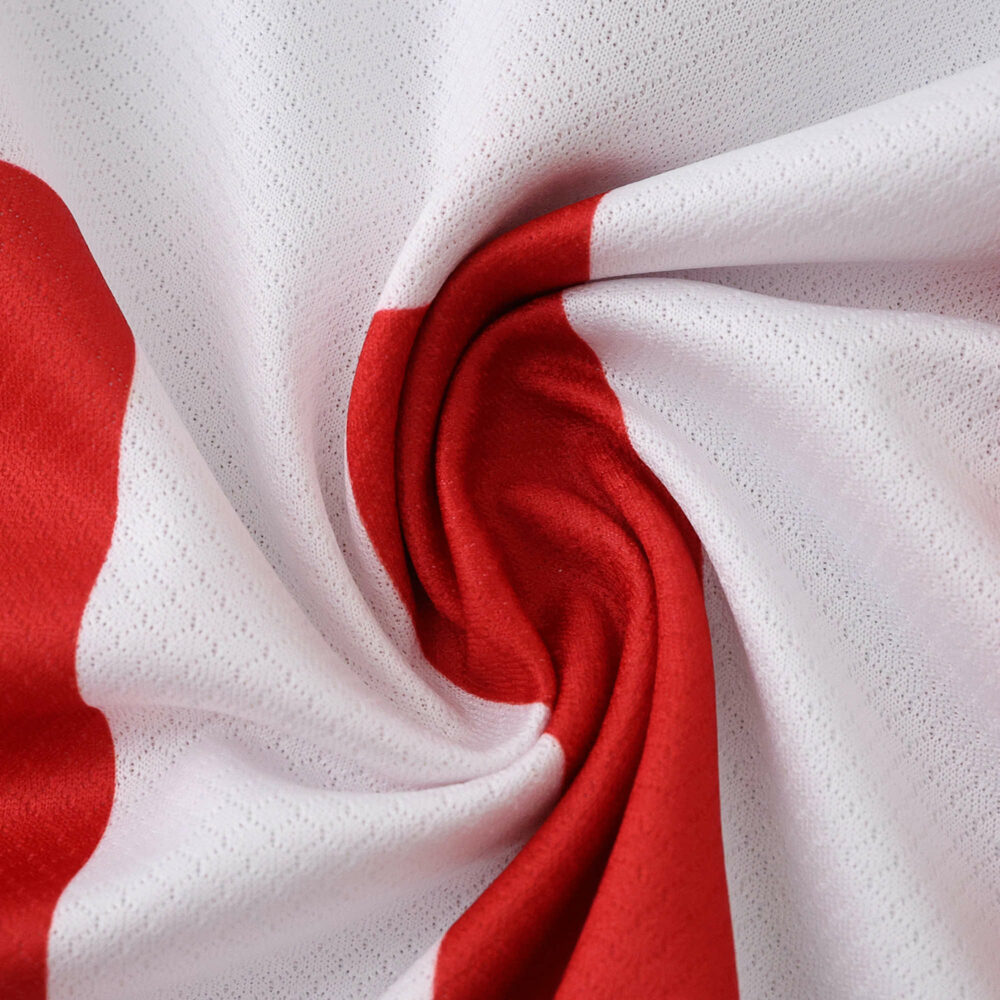 Close-up of Atlético Madrid 2025/26 home fan jersey, showing red and white fabric detail.