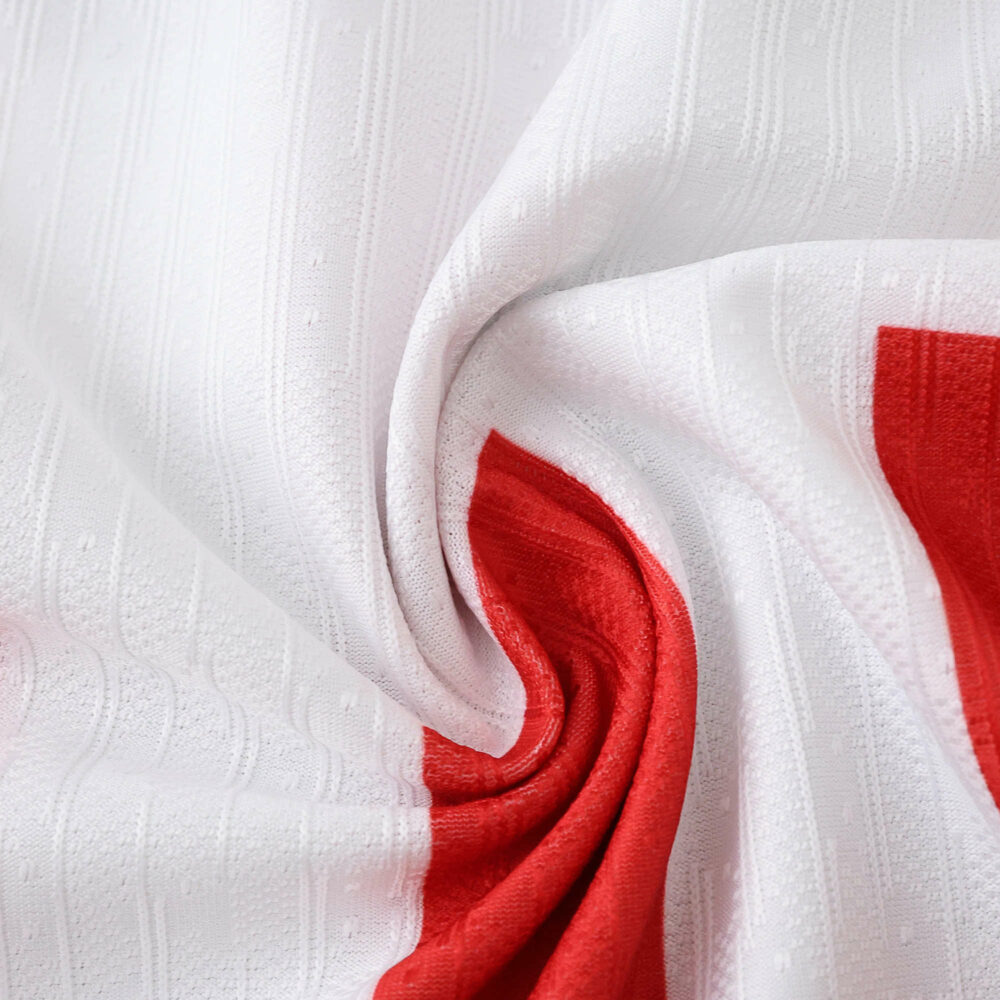 Close-up of Atlético Madrid 2025/26 Home Player Version jersey fabric showing red and white pattern.