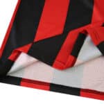 Close-up of the 2025/26 Eintracht Frankfurt home fan jersey showing red and black vertical stripes.