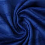 Close-up of blue Everton Home 2025/26 Fan Version jersey fabric with subtle pattern and texture.