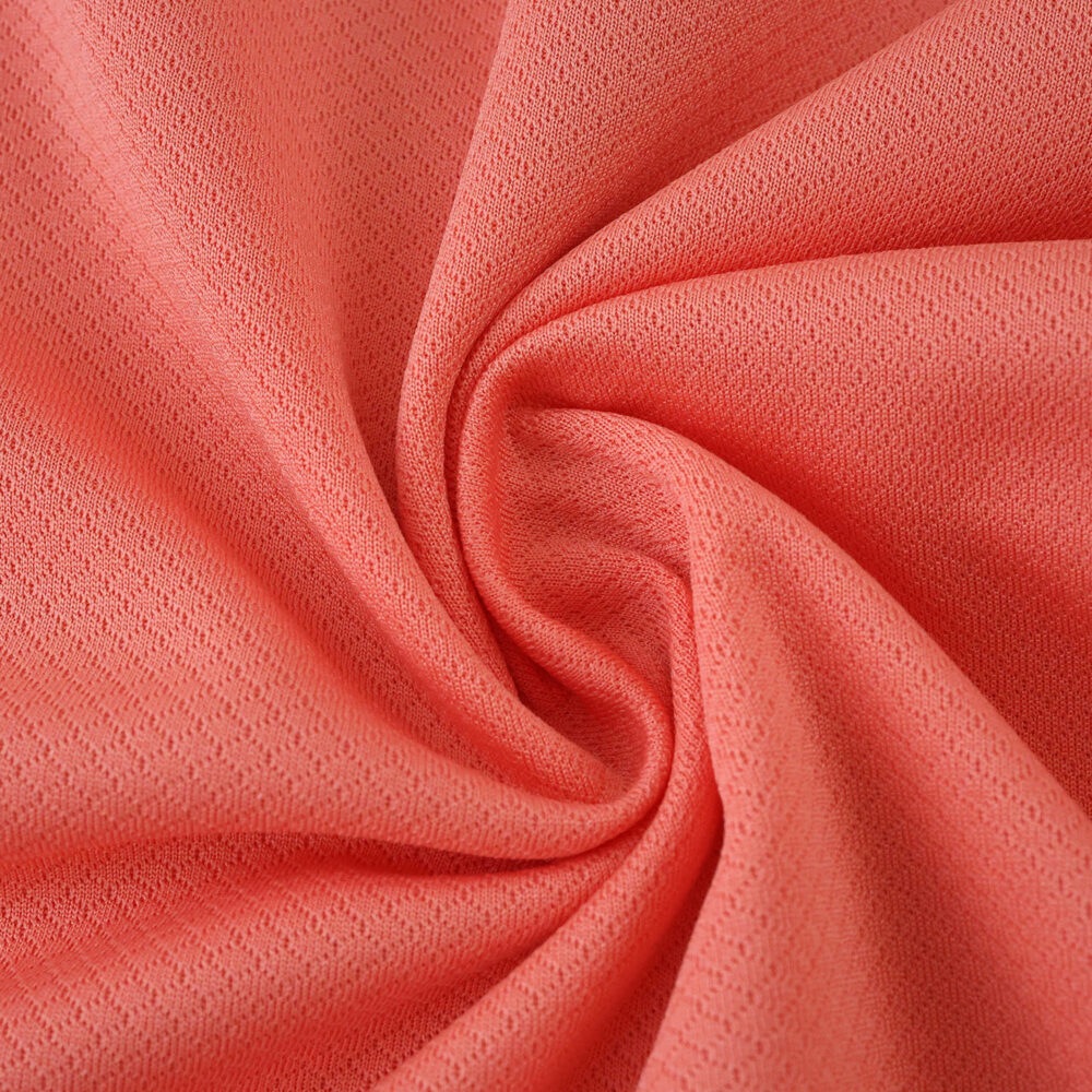Close-up of the coral pink fabric used in the FC Porto Away 2025/26 Fan Version jersey.