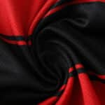 Close-up of Flamengo Home 2025/26 Player Version jersey fabric showing red and black swirl pattern.