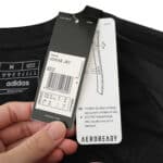 Close-up of Inter Miami CF Away 2025/26 Fan Version jersey tags, featuring size and care details.