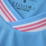 Close-up of Inter Miami CF Third 2025/26 Fan Version jersey collar in light blue with pink and white stripes.