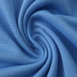 Close-up of the Manchester City 2025/26 fan home jersey fabric, showing its texture and sky blue color.