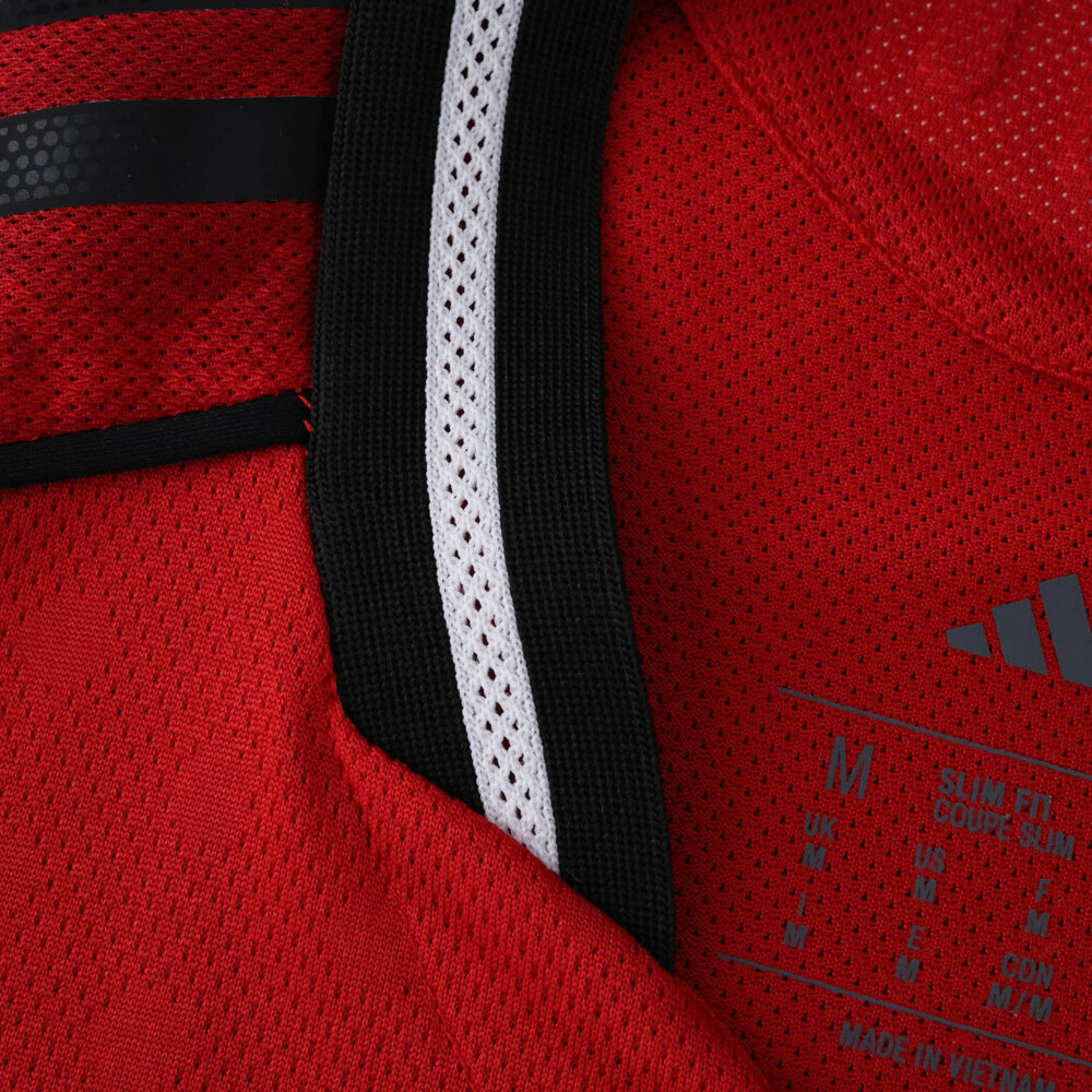 Close-up of Manchester United 2025/26 Home Player Version jersey collar and size label.