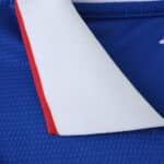 Close-up of the collar on the Rangers Home 2025/26 Fan Version jersey showing blue, white, and red details.