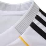 Close-up of the Real Madrid 2025/26 Home Fan jersey collar with black stripes and a yellow accent.