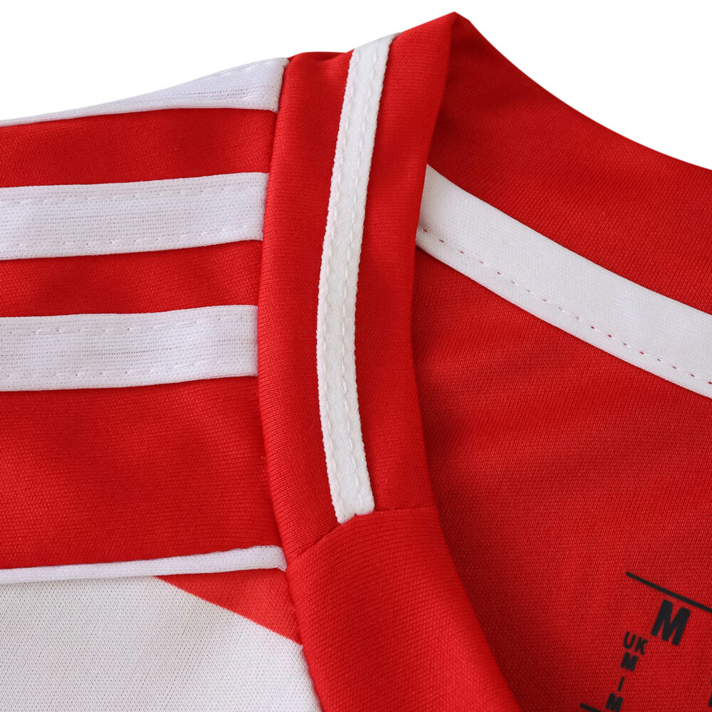 Close-up of the collar and shoulder detail on the Union Berlin 2025/26 home fan jersey, showing red and white stripes.
