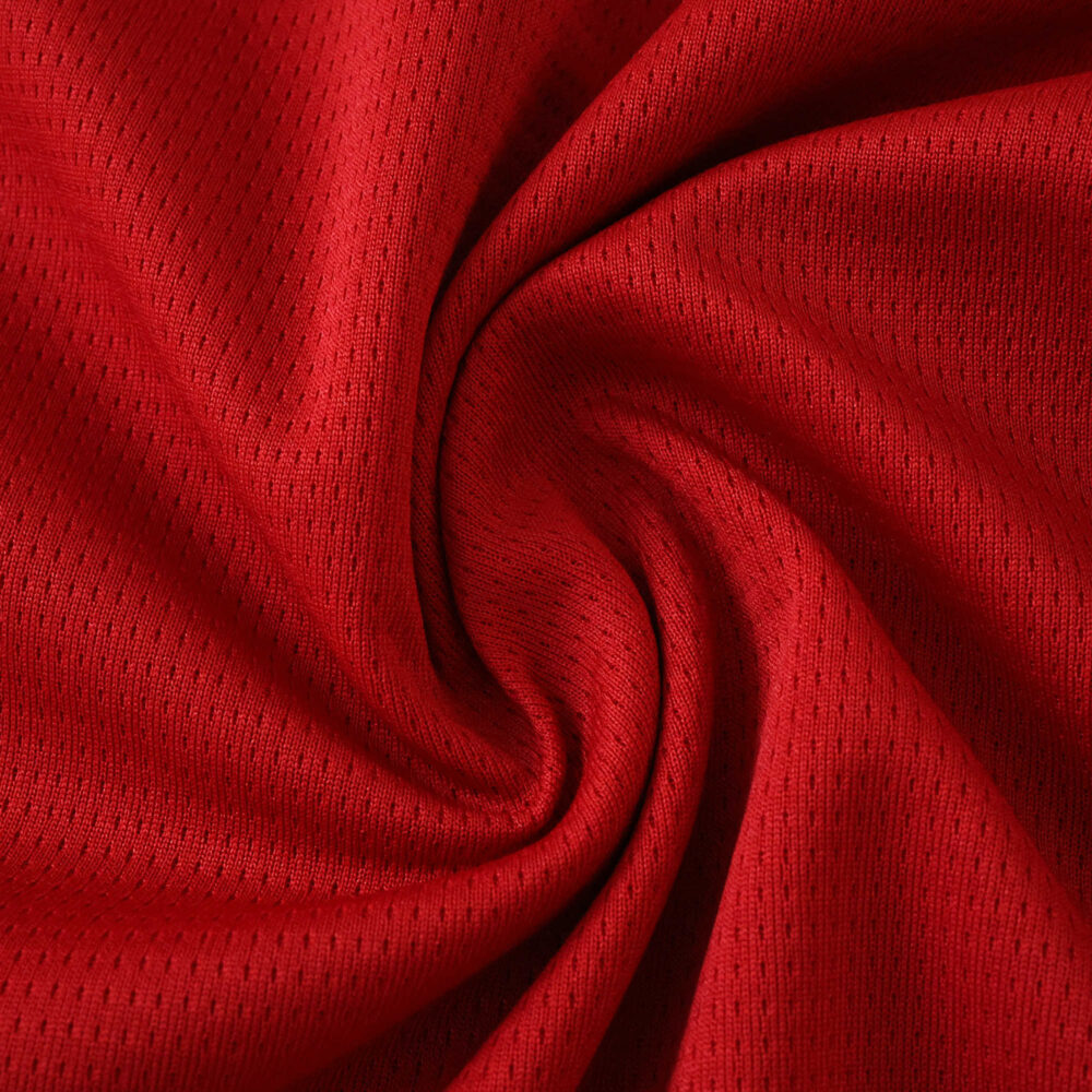 Close-up of the red fabric used in the Valencia Away 2025/26 Fan Version jersey, showing texture and weave.