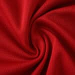 Close-up of the red fabric used in the Valencia Away 2025/26 Fan Version jersey, showing texture and weave.