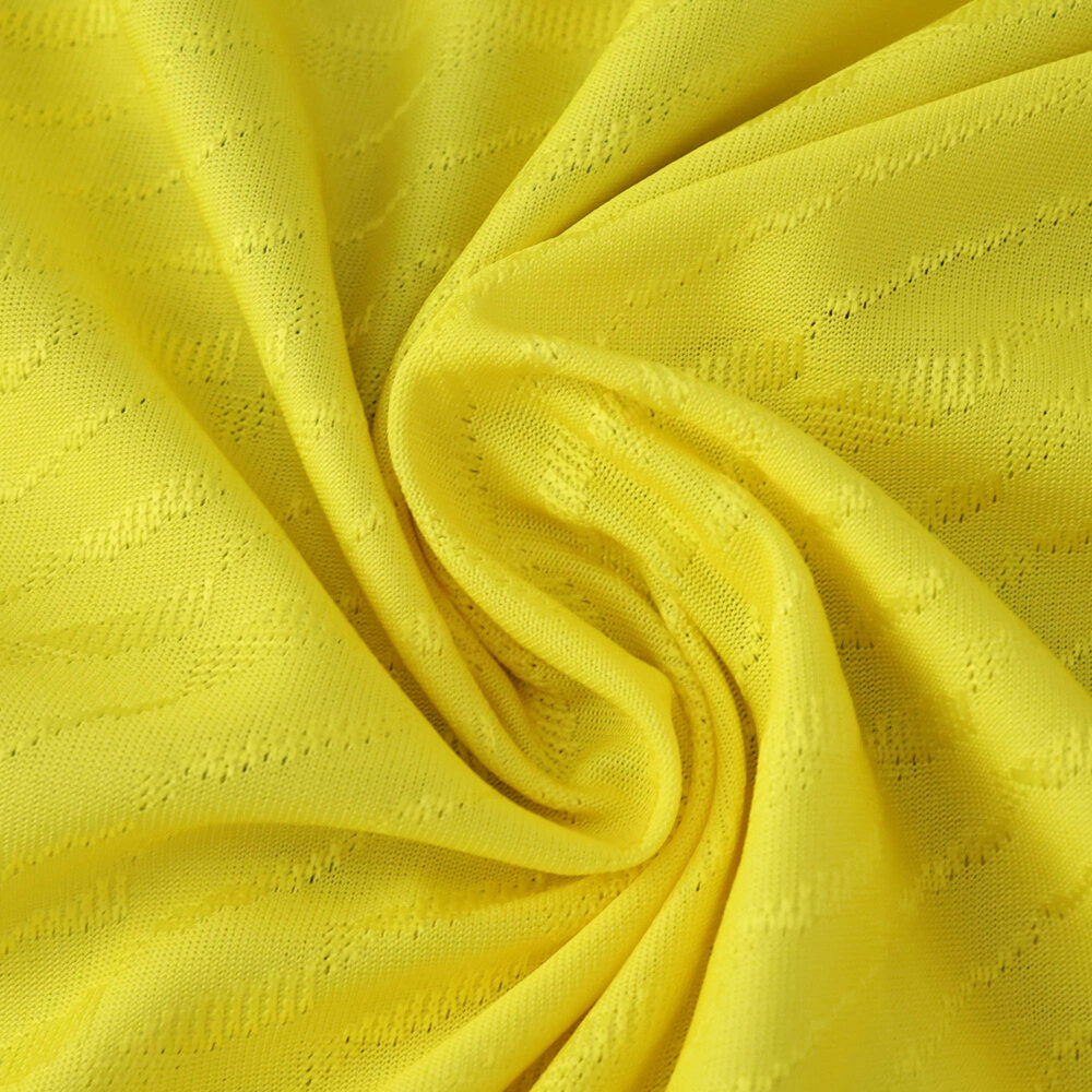 Close-up of Villarreal Home 2025/26 Player Version jersey fabric showing yellow textured material.
