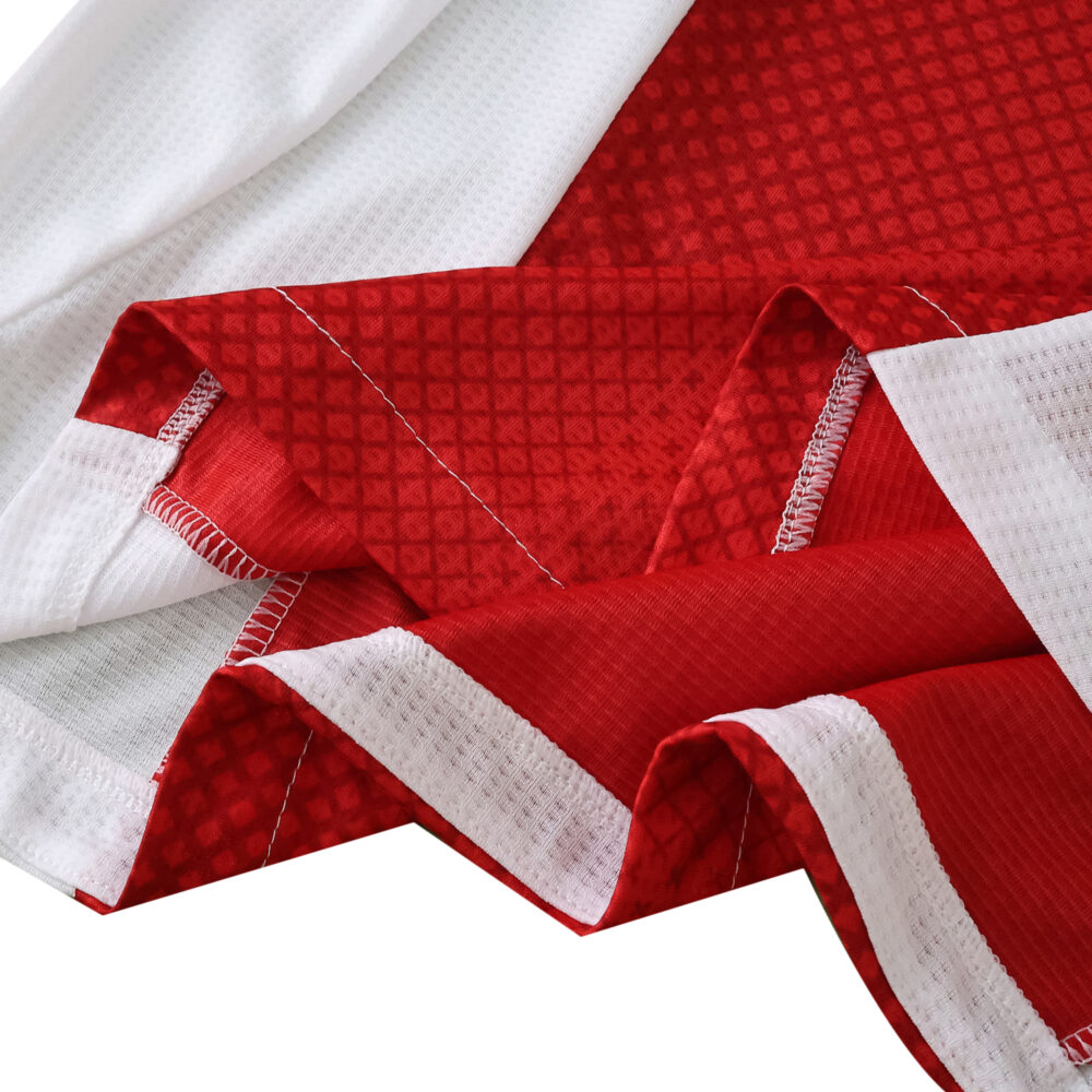 Close-up of Ajax Home 2025/26 Player Version jersey fabric showing red and white textured material.