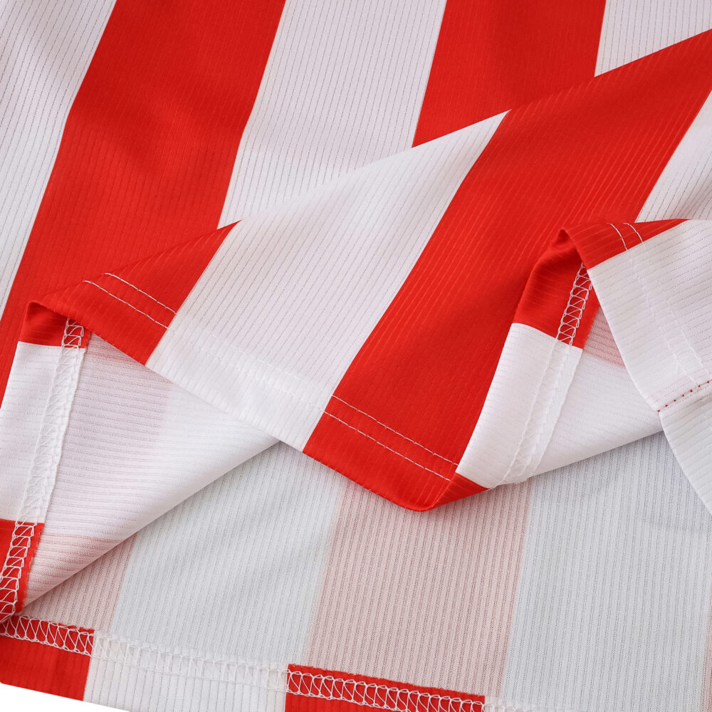 Close-up of Athletic Bilbao 2025/26 home fan jersey showing red and white vertical stripes and stitching.