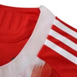 Close-up of Bayern Munich 2025/26 Home Player Version jersey collar with white stripes on red fabric.