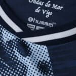 Close-up of Celta Vigo Away 2025/26 Fan Version jersey collar with Hummel branding and printed design.