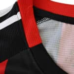 Close-up of Eintracht Frankfurt 2025/26 home fan jersey collar featuring red, black, and white details.