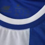 Close-up of FC Porto 2025/26 home fan jersey collar showing blue and white stripes and New Balance logo.