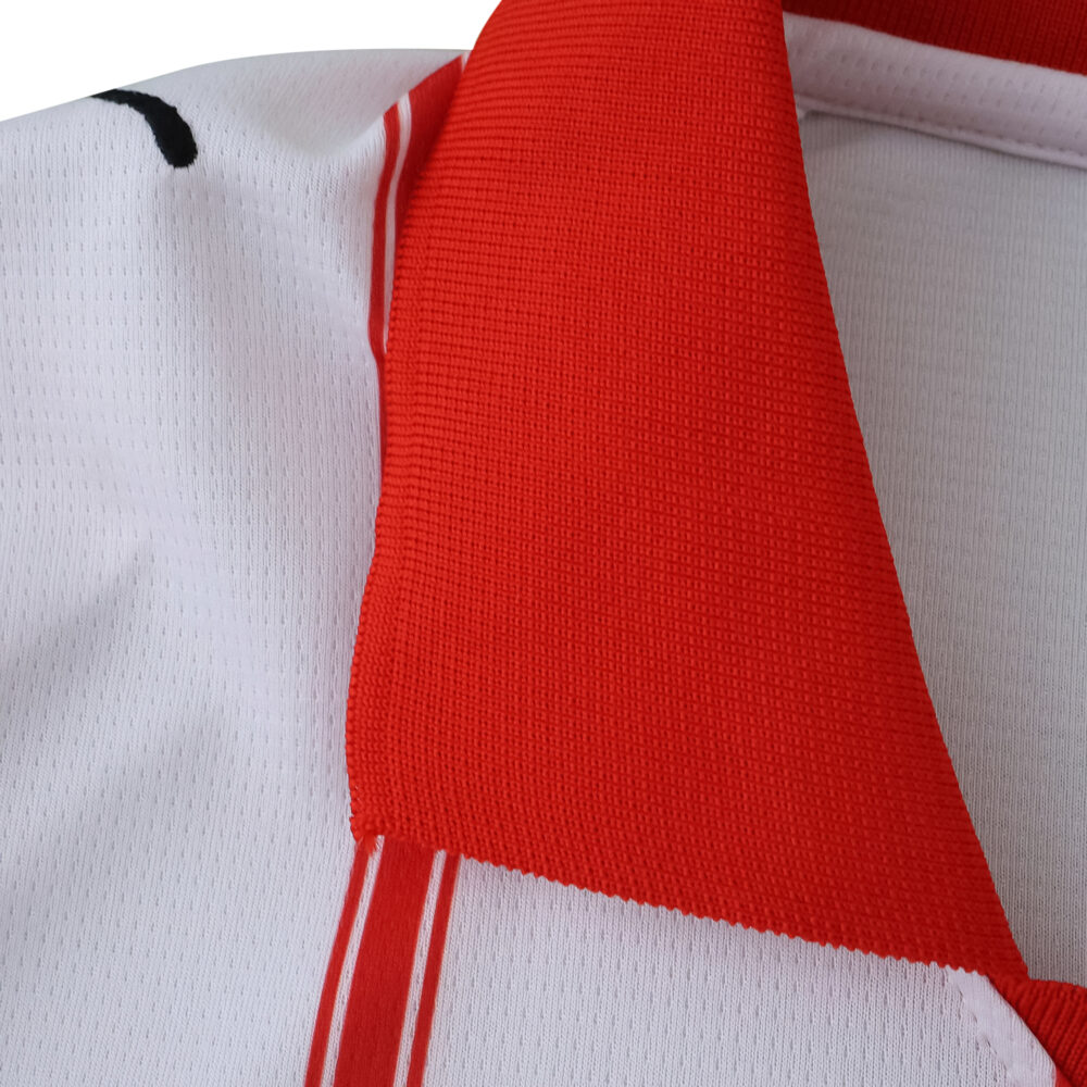 Close-up of the red collar and white fabric with stripes on the Girona Home 2025/26 Fan Version jersey.