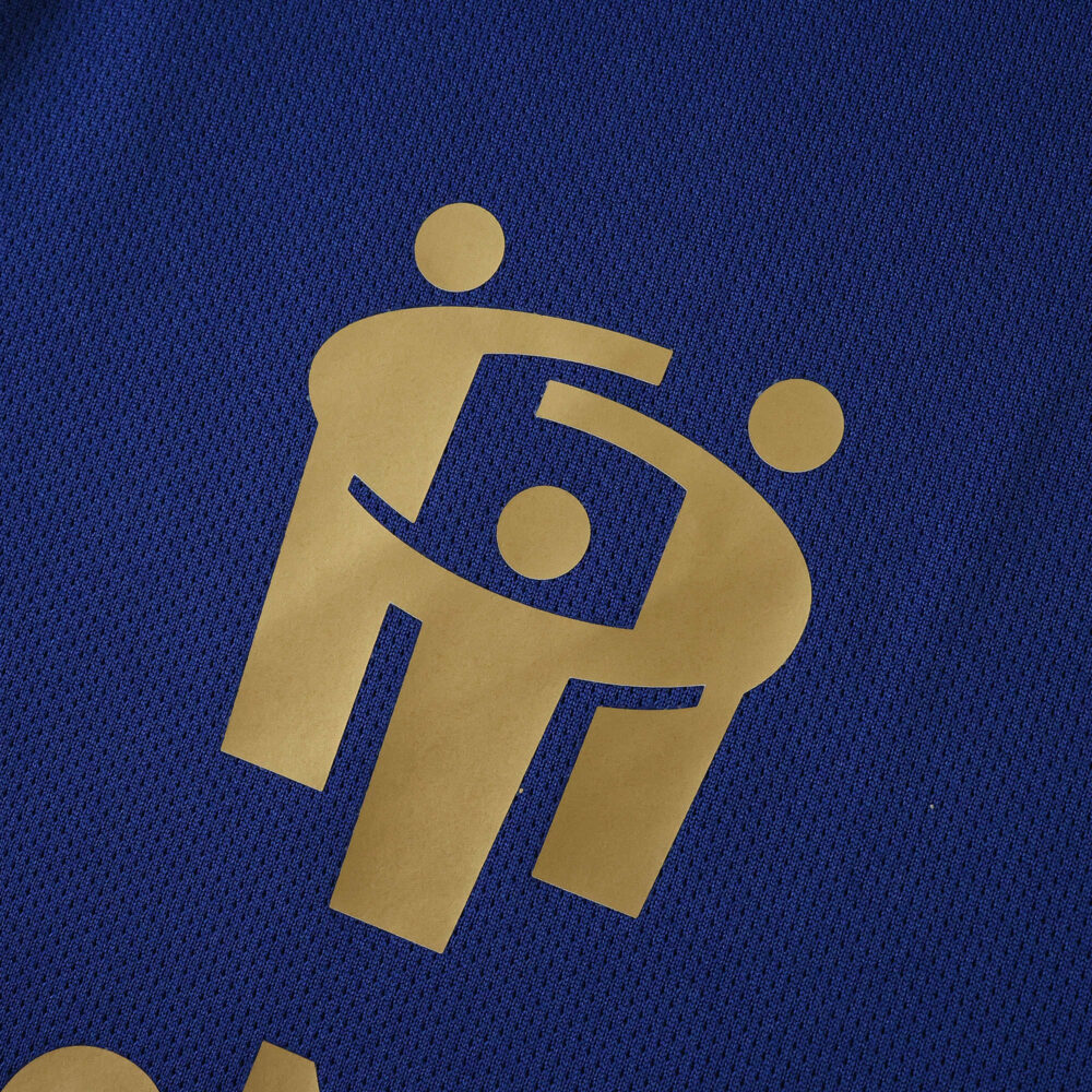 Close-up of gold sponsor logo on blue Hamburger SV Away 2025/26 Fan Version jersey fabric.