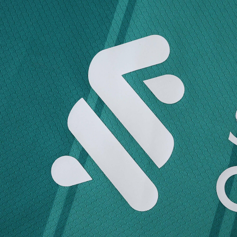 Close-up of white Liverpool 2025/26 third kit logo on teal fabric, fan version jersey.