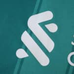 Close-up of white Liverpool 2025/26 third kit logo on teal fabric, fan version jersey.