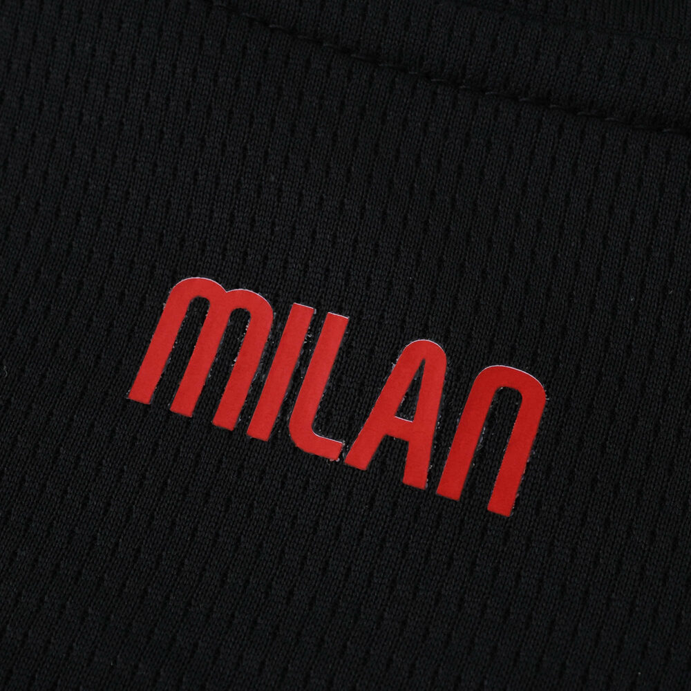 Close-up of "MILAN" in red lettering on the AC Milan Home 2025/26 Fan Version jersey fabric.