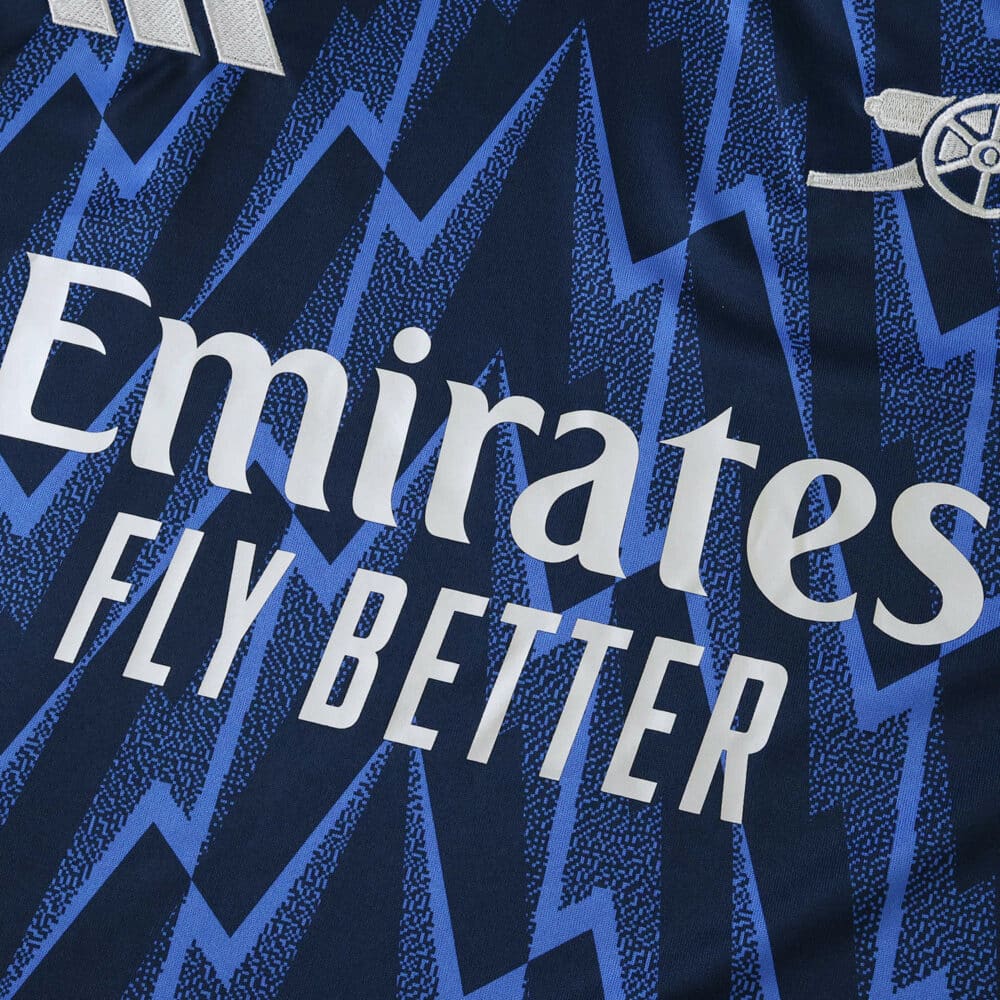 Close-up of Arsenal Away 2025/26 Fan Version jersey with blue zigzag pattern and Emirates Fly Better logo.