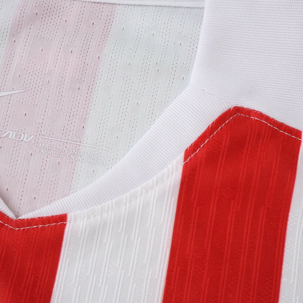 Close-up of the 2025/26 Atlético Madrid Home Player Version jersey, showing red and white stripes and collar.