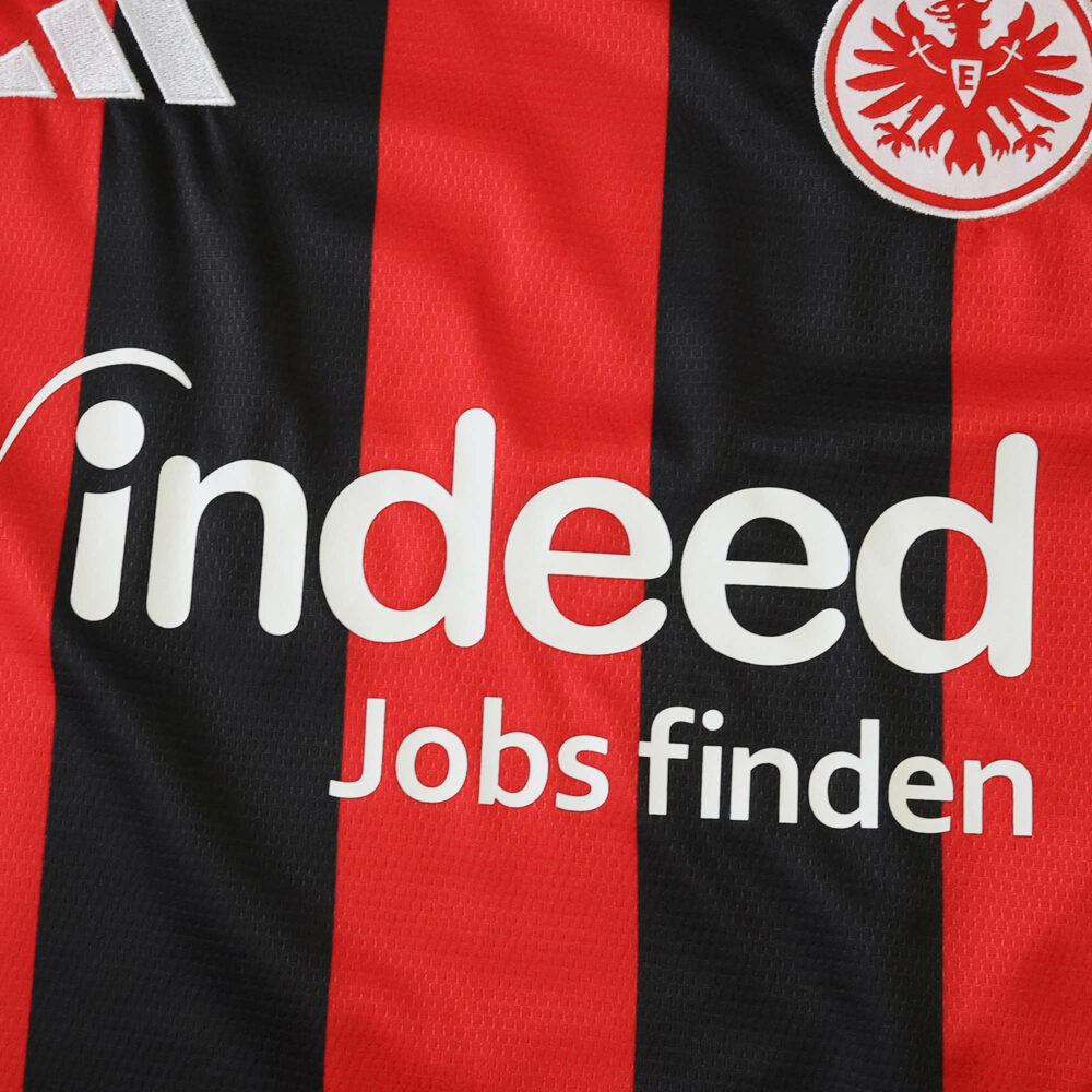 Close-up of Eintracht Frankfurt 2025/26 home fan jersey, featuring sponsor and club crest.