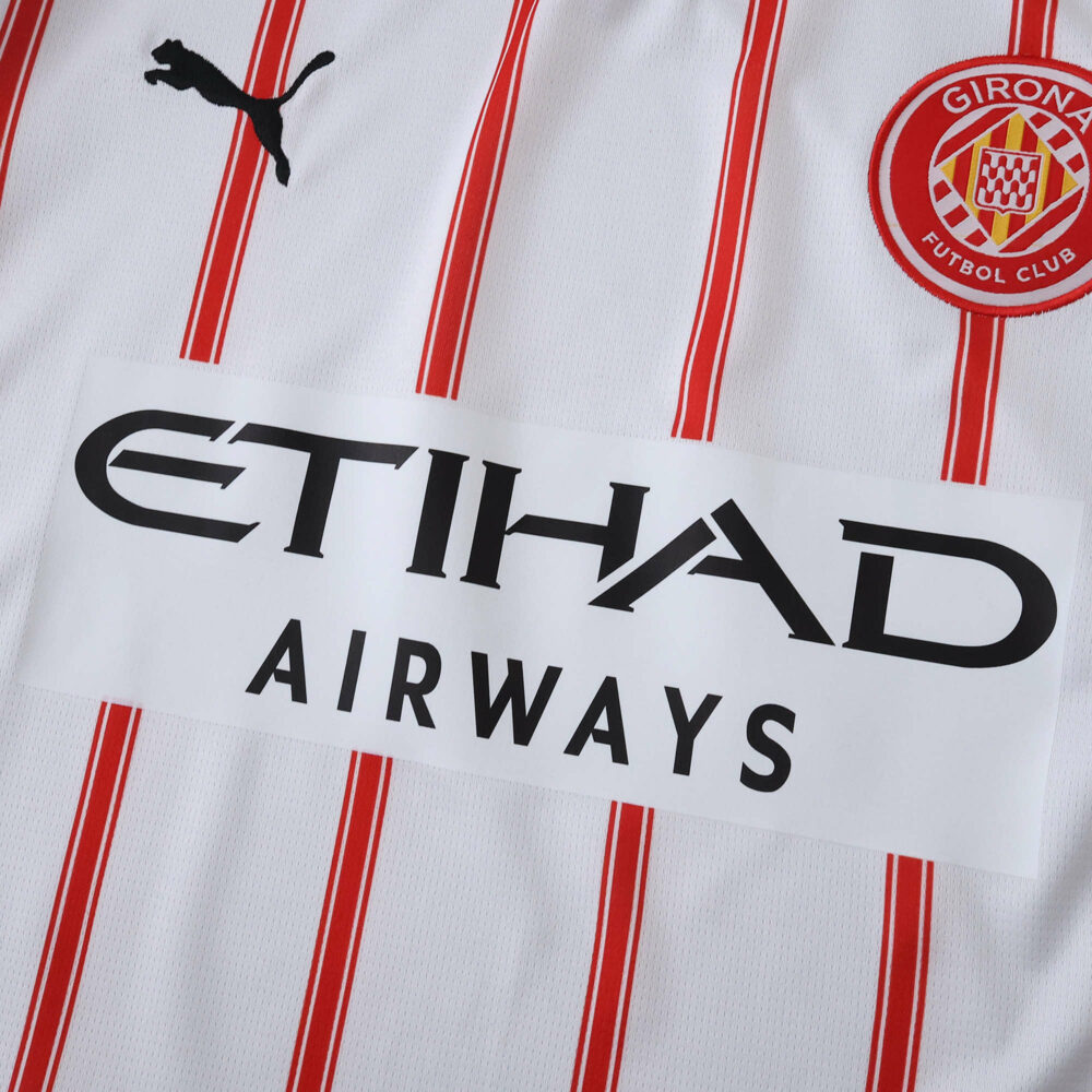 Close-up of Girona Home 2025/26 fan jersey with red stripes and Etihad Airways sponsor logo.