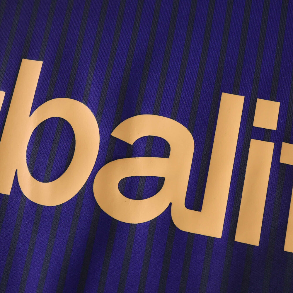 Close-up of LA Galaxy Away 2025/26 Fan Version jersey, showing gold lettering on dark blue striped fabric.