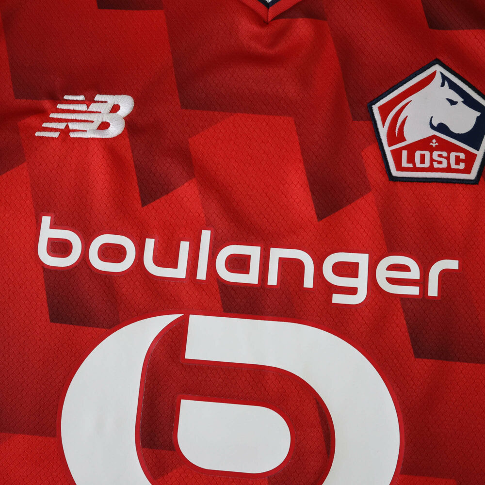 Close-up of Lille LOSC 2025/26 Home Fan jersey showing club crest, sponsor logos, and red geometric pattern.