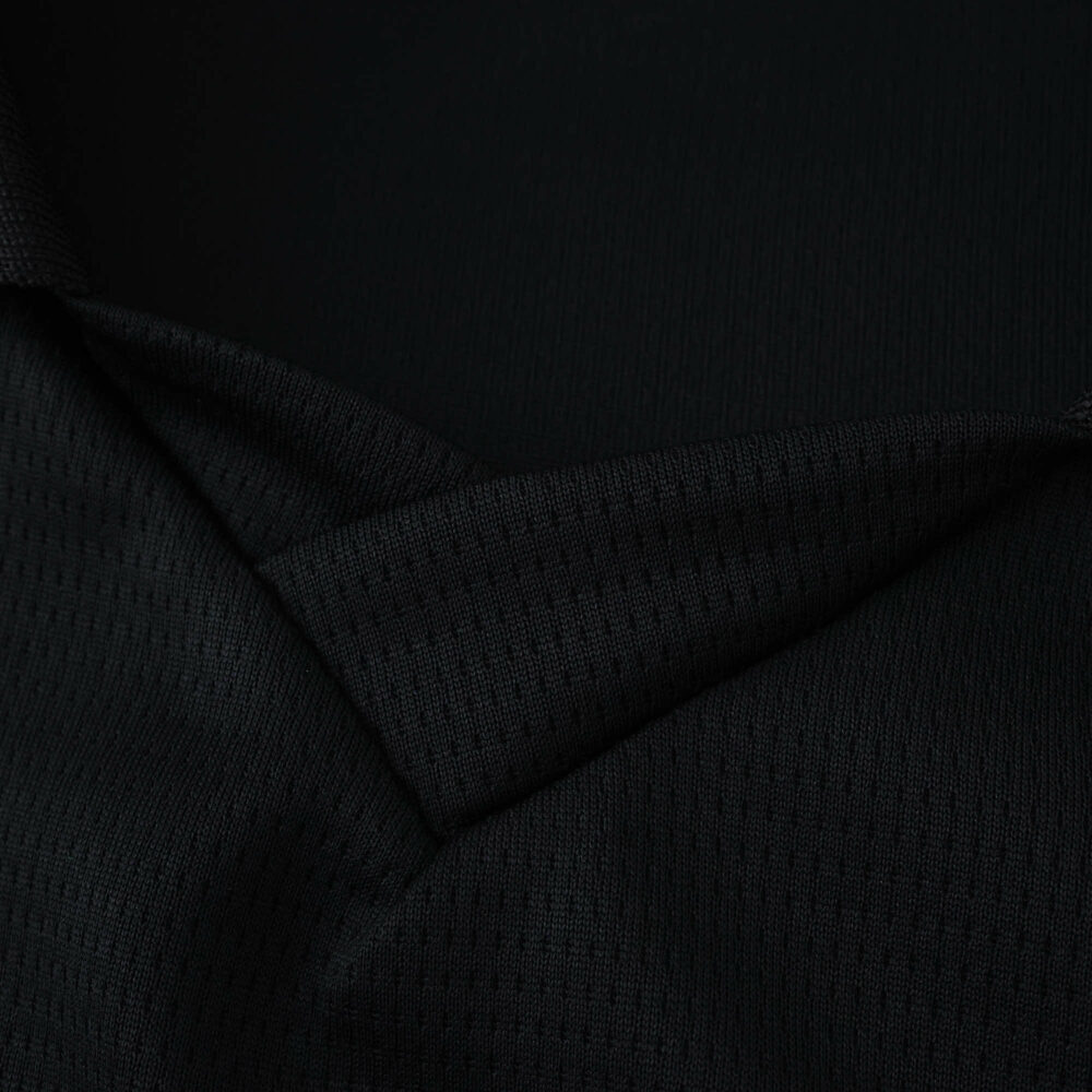 Close-up of the Manchester City Away 2025/26 Fan Version jersey fabric in dark material.