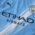 Close-up of Manchester City 2025/26 home player jersey featuring club badge, Puma logo, and Etihad Airways sponsor.
