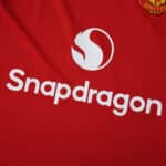 Close-up of the Manchester United 2025/26 home fan jersey with Snapdragon sponsor logo on red fabric.