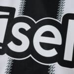 Close-up of Newcastle United 2025/26 home fan jersey showing part of the sponsor logo on black and white stripes.